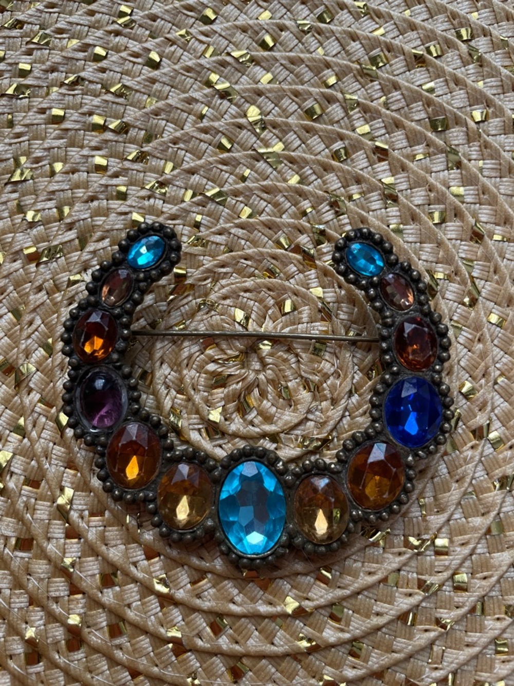 Arch style brooch with blues, oranges and yellow jewels